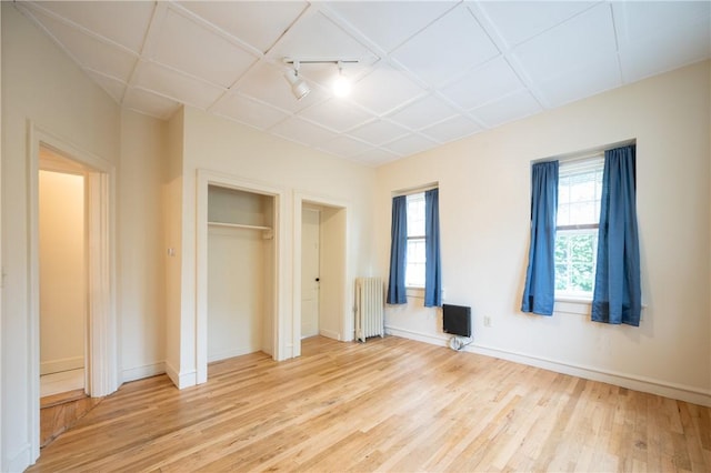 10 Hendricks St, South Kingstown, RI 02879 - unfurnished bedroom featuring radiator heating unit, light wood-style flooring, multiple windows, and a closet