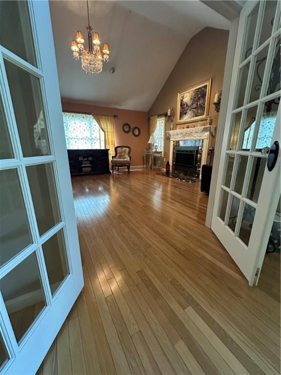 14 Piezzo Dr, Westerly, RI 02891 - unfurnished living room with a chandelier, a premium fireplace, plenty of natural light, lofted ceiling, and wood finished floors