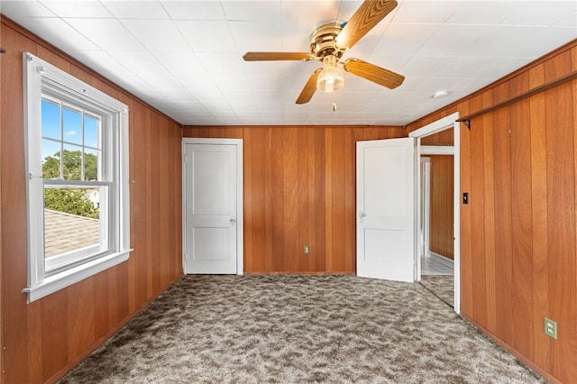 34 Tilden Ave, Warwick, RI 02888 - unfurnished bedroom featuring carpet floors, wood walls, and ceiling fan
