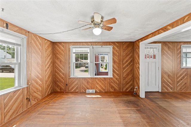 34 Tilden Ave, Warwick, RI 02888 - unfurnished room with hardwood / wood-style floors, ceiling fan, healthy amount of natural light, wood walls, and a textured ceiling
