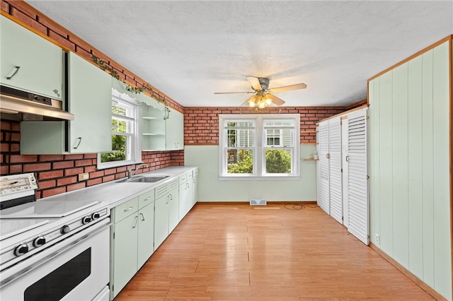 34 Tilden Ave, Warwick, RI 02888 - kitchen featuring white range oven, under cabinet range hood, light wood finished floors, light countertops, and brick wall