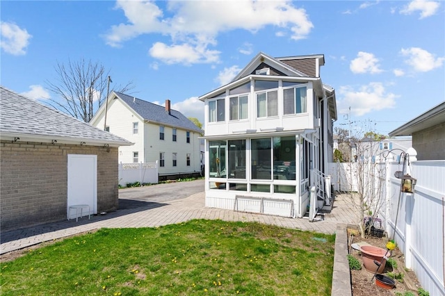 167 Carter Ave, Pawtucket, RI 02861 - rear view of house featuring a sunroom, a fenced backyard, and a patio