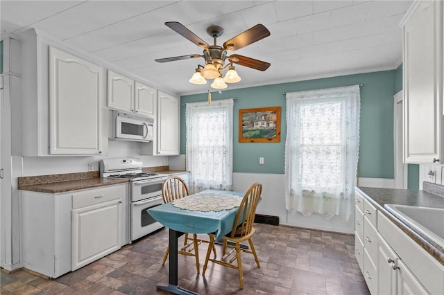 167 Carter Ave, Pawtucket, RI 02861 - kitchen with white appliances, plenty of natural light, white cabinetry, and ornamental molding