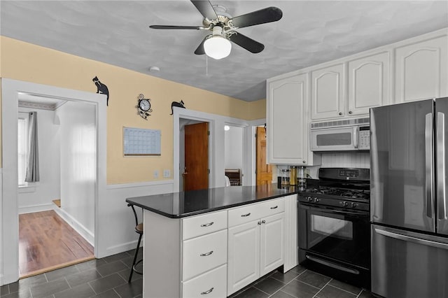 167 Carter Ave, Pawtucket, RI 02861 - kitchen with freestanding refrigerator, white microwave, black gas range oven, a peninsula, and white cabinetry