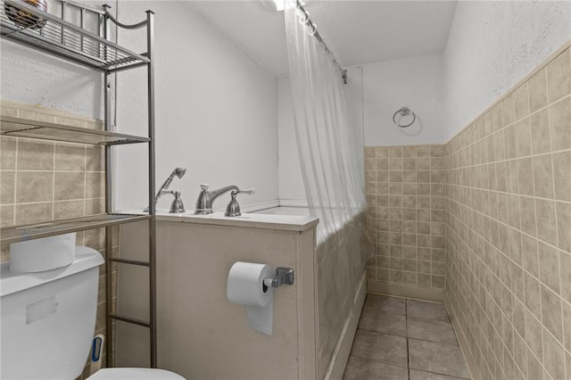 167 Carter Ave, Pawtucket, RI 02861 - bathroom with tile walls, tiled shower, tile patterned floors, and wainscoting
