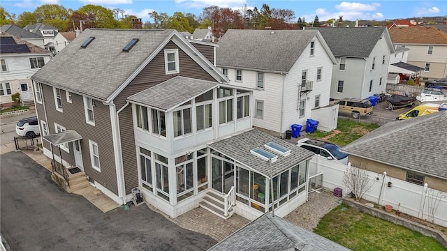 167 Carter Ave, Pawtucket, RI 02861 - rear view of property with a sunroom, a fenced backyard, a chimney, a shingled roof, and a residential view