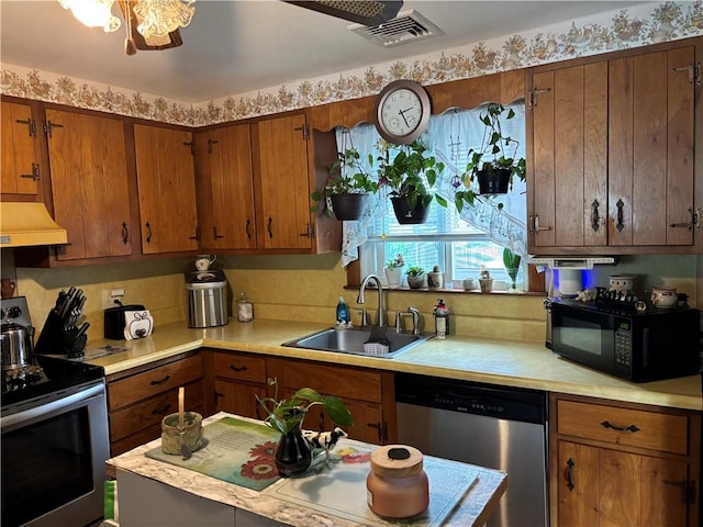 70 Partition St, Warwick, RI 02888 - kitchen featuring stainless steel appliances, light countertops, premium range hood, and brown cabinets