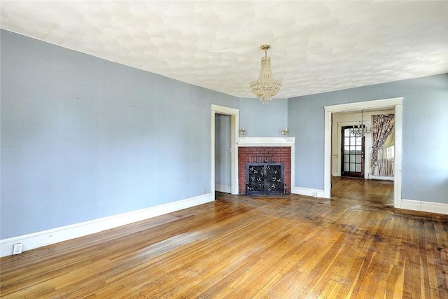 59 Colonial Ave, Cranston, RI 02910 - unfurnished living room with a chandelier, hardwood / wood-style flooring, and a fireplace