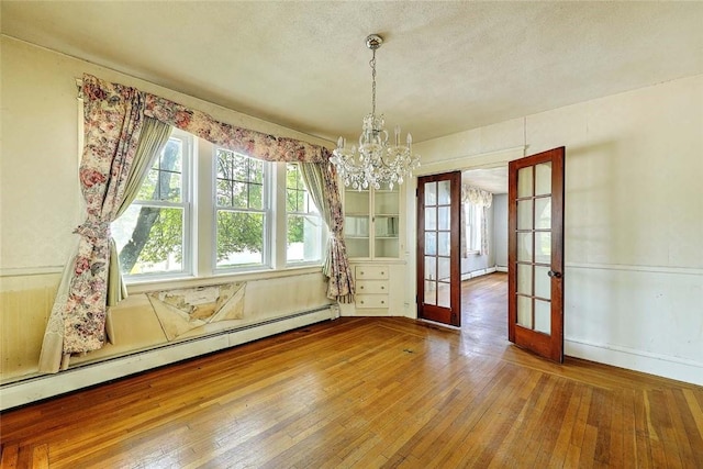 59 Colonial Ave, Cranston, RI 02910 - unfurnished dining area with a baseboard heating unit, french doors, a chandelier, and hardwood / wood-style flooring