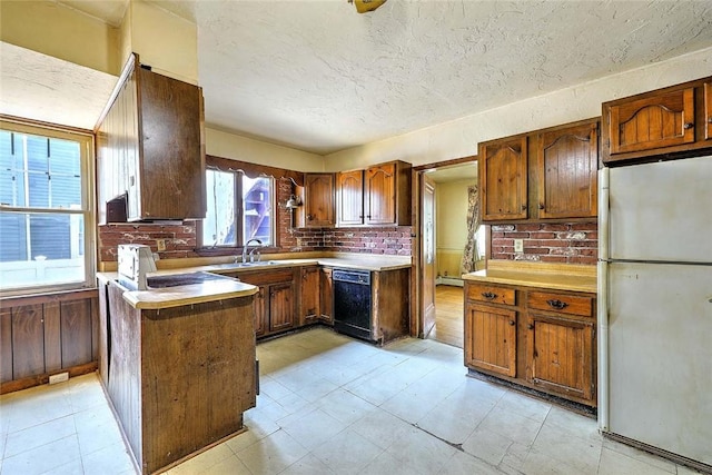 59 Colonial Ave, Cranston, RI 02910 - kitchen with freestanding refrigerator, black dishwasher, a peninsula, a textured ceiling, and light countertops
