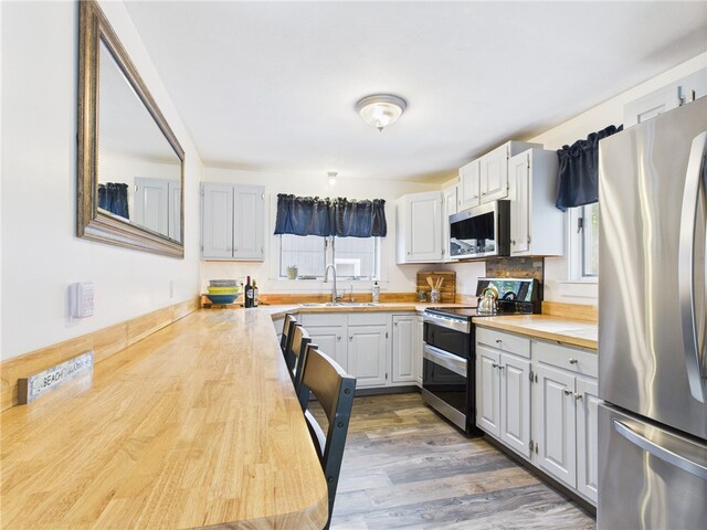 34 Beach Plum Rd, Narragansett, RI 02882 - kitchen with appliances with stainless steel finishes, healthy amount of natural light, wood finished floors, and wooden counters