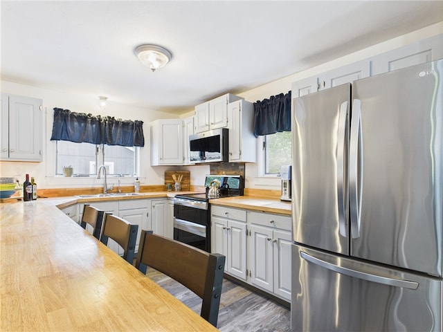 34 Beach Plum Rd, Narragansett, RI 02882 - kitchen featuring appliances with stainless steel finishes, butcher block countertops, wood finished floors, and white cabinetry