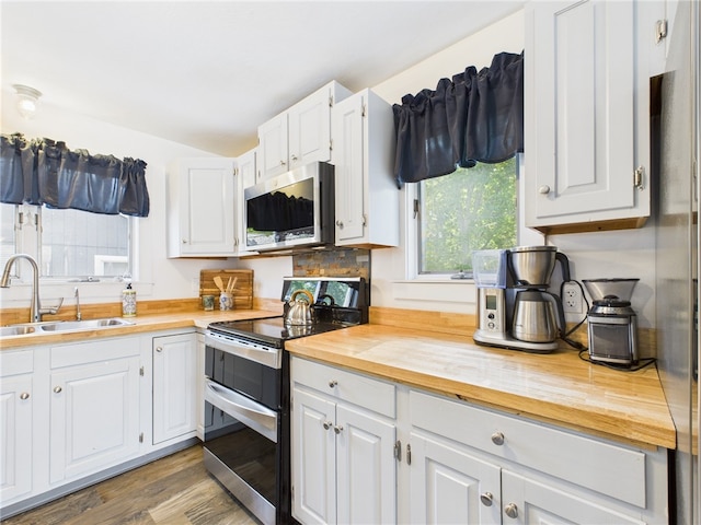 34 Beach Plum Rd, Narragansett, RI 02882 - kitchen with appliances with stainless steel finishes, wooden counters, wood finished floors, and white cabinets