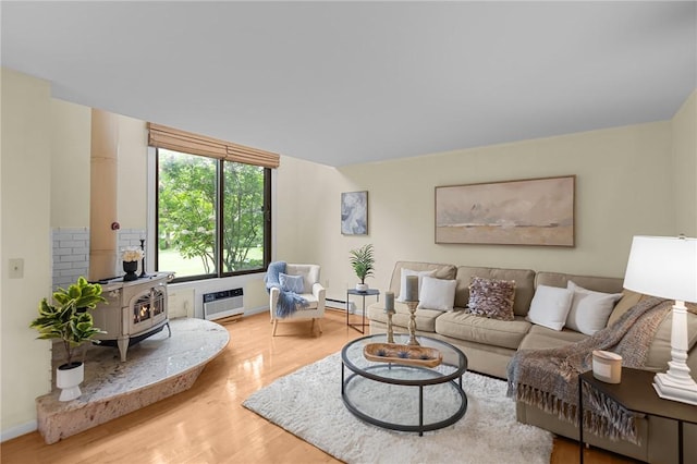 180 Fishing Cove Rd, North Kingstown, RI 02852 - living area featuring a wood stove, wood finished floors, a wall unit AC, and a baseboard radiator