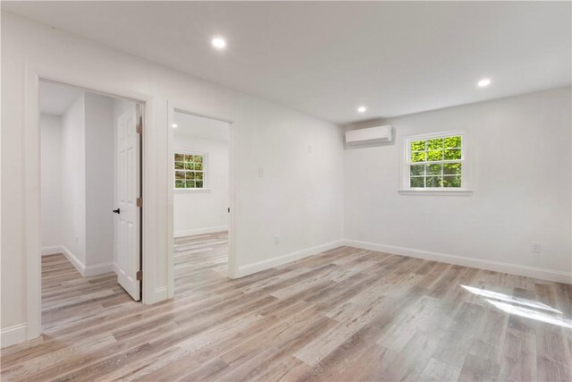 226 Quaker Ln, Scituate, RI 02857 - empty room with a wall mounted air conditioner, light wood finished floors, and recessed lighting