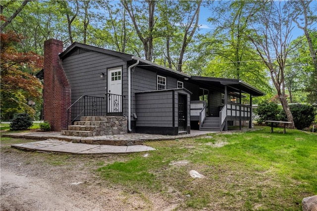 226 Quaker Ln, Scituate, RI 02857 - view of front of property with a chimney, a front lawn, and a wooden deck