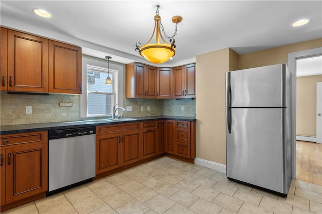 74 Park View Blvd, Cranston, RI 02910 - kitchen with stainless steel appliances, dark countertops, brown cabinetry, decorative backsplash, and pendant lighting