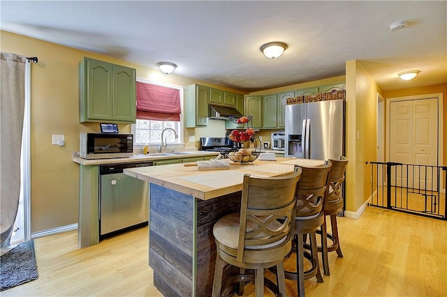 39 Old Onset Rd, Wareham, MA 02558 - kitchen featuring stainless steel appliances, green cabinetry, under cabinet range hood, and light wood-type flooring