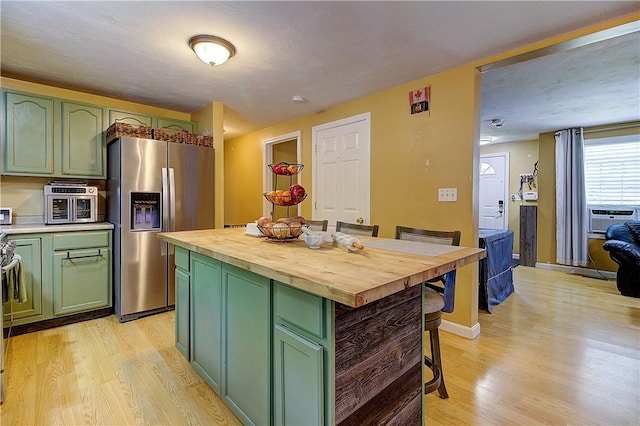 39 Old Onset Rd, Wareham, MA 02558 - kitchen with green cabinetry, stainless steel fridge, wood counters, a kitchen breakfast bar, and light wood-style floors