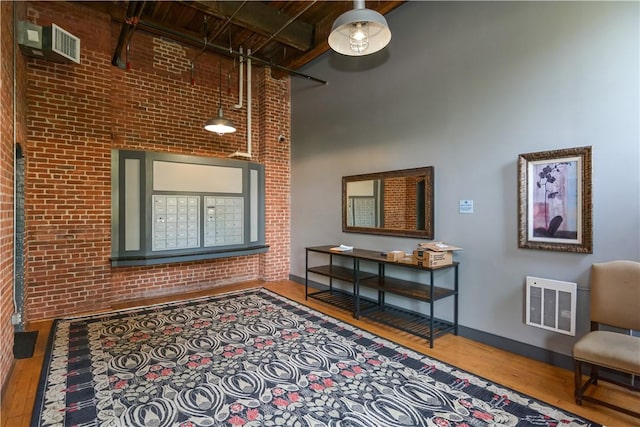 685 Social St Unit 103, Woonsocket, RI 02895 - living area with brick wall, wood finished floors, and a high ceiling