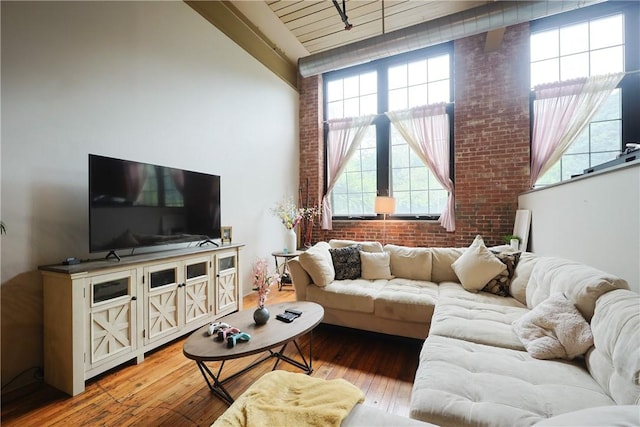 685 Social St Unit 103, Woonsocket, RI 02895 - living area with brick wall, high vaulted ceiling, light wood-style floors, and plenty of natural light