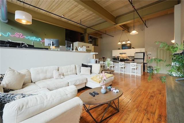 685 Social St Unit 103, Woonsocket, RI 02895 - living area featuring wood-type flooring, a towering ceiling, and a wood ceiling with exposed beams