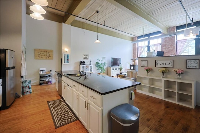 685 Social St Unit 103, Woonsocket, RI 02895 - kitchen with appliances with stainless steel finishes, white cabinetry, dark countertops, light wood-type flooring, and pendant lighting