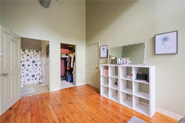 685 Social St Unit 103, Woonsocket, RI 02895 - unfurnished bedroom featuring a high ceiling, wood-type flooring, a walk in closet, and a closet