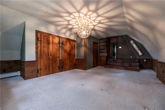 84 Skunk Hill Rd, Hopkinton, RI 02832 - unfurnished living room featuring wood walls, lofted ceiling, a baseboard heating unit, carpet floors, and a wainscoted wall