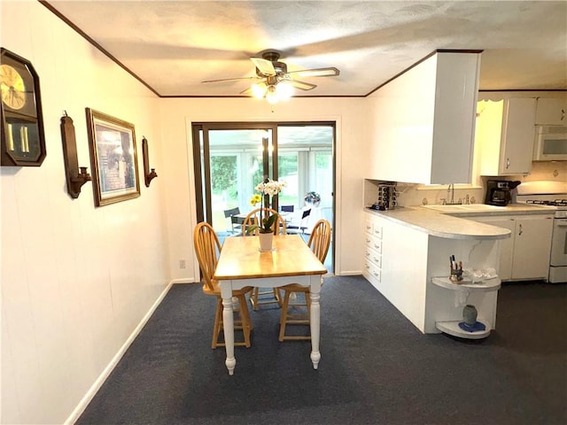 51 Old Carriage Rd, West Warwick, RI 02893 - dining room featuring ceiling fan, ornamental molding, and dark colored carpet