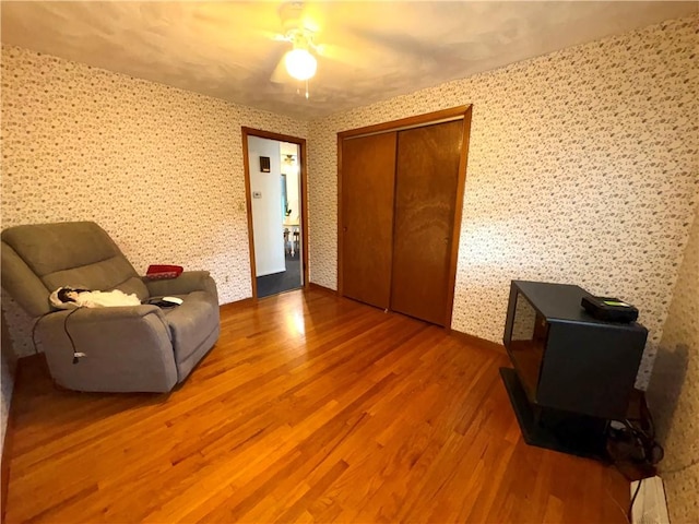 51 Old Carriage Rd, West Warwick, RI 02893 - sitting room with wood finished floors, ceiling fan, and wallpapered walls