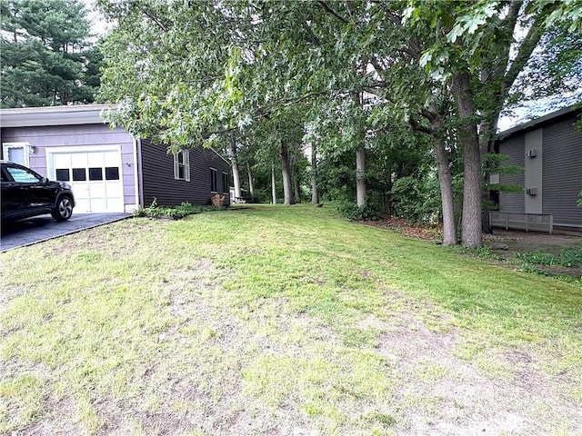 51 Old Carriage Rd, West Warwick, RI 02893 - view of grassy yard featuring an attached garage and asphalt driveway