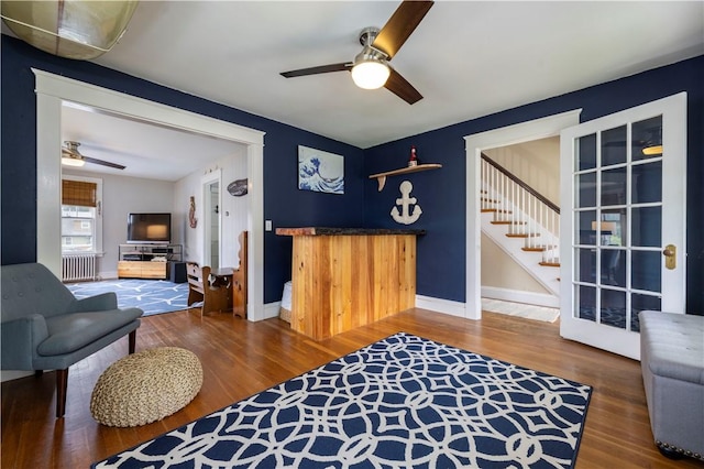 39 Chester Ave, Westerly, RI 02891 - living area with ceiling fan, radiator heating unit, wood finished floors, and stairs
