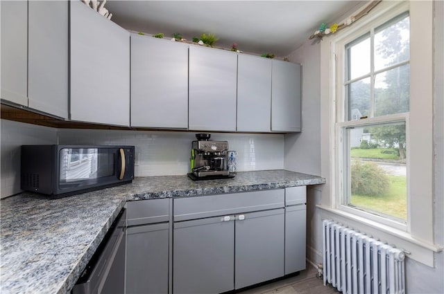 39 Chester Ave, Westerly, RI 02891 - kitchen with radiator, black microwave, tasteful backsplash, and dishwasher