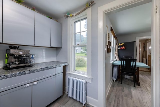 39 Chester Ave, Westerly, RI 02891 - kitchen featuring radiator, light wood finished floors, decorative backsplash, and fridge
