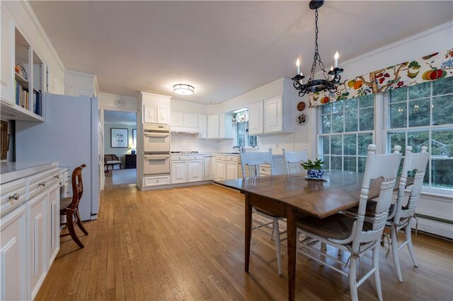 38 Setting Sun Dr, Westerly, RI 02891 - dining area featuring light wood-style flooring, healthy amount of natural light, a chandelier, and crown molding