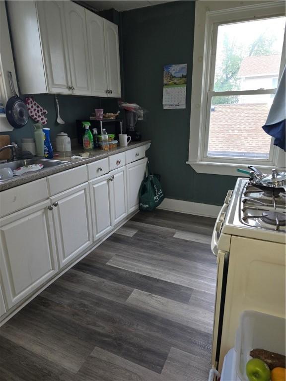 33 Chambers St, Providence, RI 02907 - kitchen with gas range gas stove, white cabinetry, healthy amount of natural light, and dark wood-style flooring