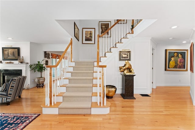 27 Eagle Dr, North Kingstown, RI 02852 - stairway with wood finished floors, ornamental molding, recessed lighting, and a premium fireplace