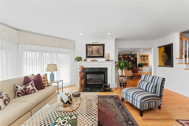 27 Eagle Dr, North Kingstown, RI 02852 - living area with wood finished floors, a fireplace with flush hearth, stairway, recessed lighting, and crown molding
