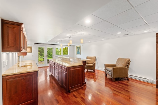 27 Eagle Dr, North Kingstown, RI 02852 - kitchen with dark wood-style flooring, a baseboard radiator, french doors, light stone countertops, and open floor plan