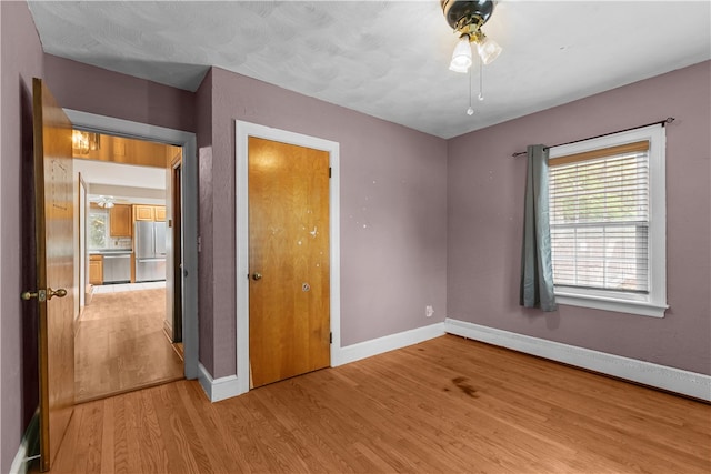 509 W Shore Rd, Warwick, RI 02889 - unfurnished bedroom featuring freestanding refrigerator, light wood-type flooring, and a closet