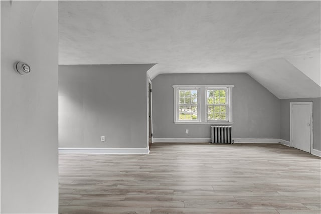 509 W Shore Rd, Warwick, RI 02889 - additional living space with radiator heating unit, vaulted ceiling, and wood finished floors