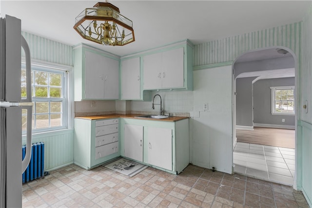 509 W Shore Rd, Warwick, RI 02889 - kitchen featuring radiator, arched walkways, a chandelier, freestanding refrigerator, and light countertops
