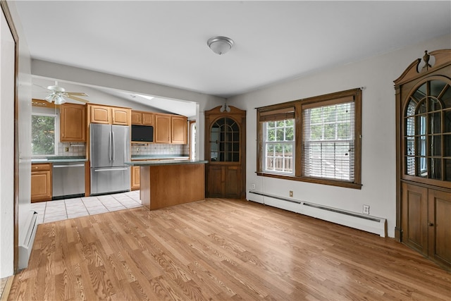 509 W Shore Rd, Warwick, RI 02889 - kitchen featuring appliances with stainless steel finishes, a baseboard radiator, decorative backsplash, light wood-style flooring, and a peninsula