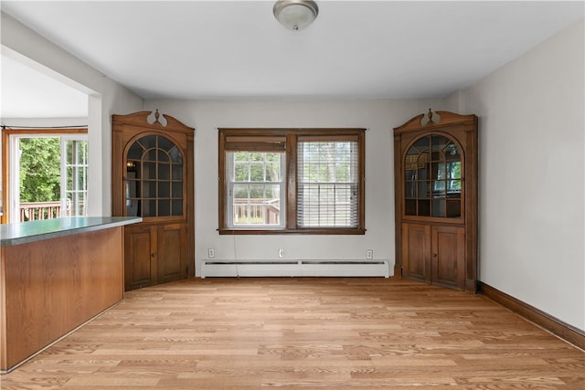 509 W Shore Rd, Warwick, RI 02889 - unfurnished dining area with a baseboard heating unit and light wood-style flooring
