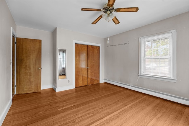 509 W Shore Rd, Warwick, RI 02889 - unfurnished bedroom with baseboard heating, a closet, wood finished floors, and ceiling fan