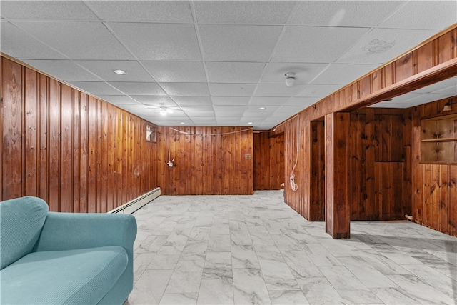 509 W Shore Rd, Warwick, RI 02889 - finished below grade area featuring a baseboard heating unit, wooden walls, light marble finish flooring, a drop ceiling, and recessed lighting