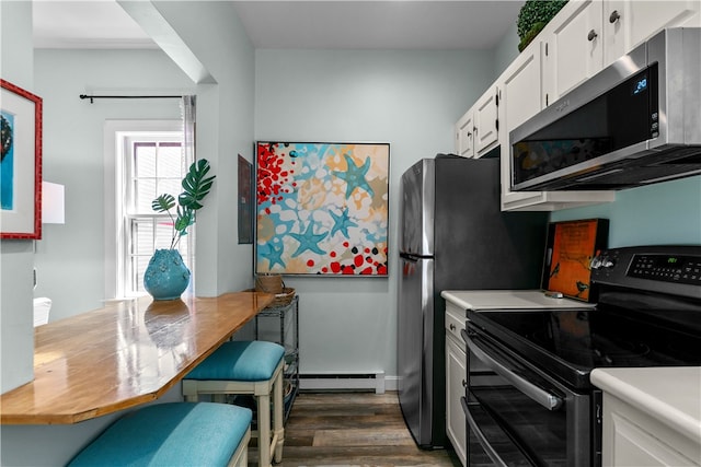 97 Narragansett Ave Unit C4, Newport, RI 02840 - kitchen with black range with electric cooktop, stainless steel microwave, dark wood-style floors, white cabinetry, and light countertops