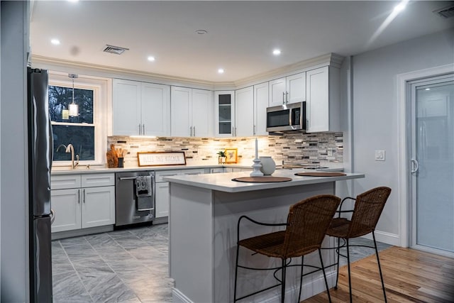 945 Danielson Pike, Scituate, RI 02857 - kitchen featuring appliances with stainless steel finishes, a breakfast bar, tasteful backsplash, glass insert cabinets, and recessed lighting