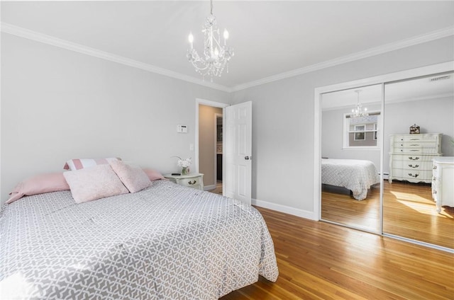 25 Rosewood Dr, North Providence, RI 02904 - bedroom with a chandelier, wood finished floors, a closet, crown molding, and baseboard heating